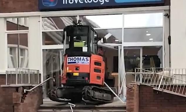 Bizarre moment furious digger driver smashes his way into new Travelodge hotel in rampage ‘over a £600 unpaid wage bill’ – on the day builders had finished their work