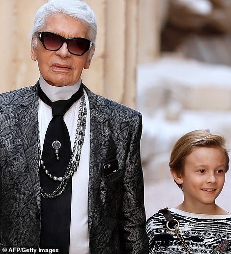 Karl Lagerfeld posing with his beautiful Birman cat in a photo from Choupette's official Instagram (left) and with his godson Hudson (right) another potential heir to his fortune